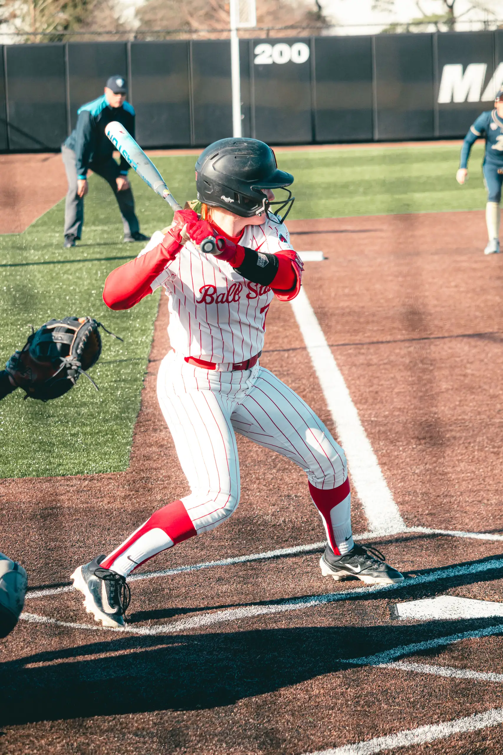 Maia Pietrzak at the plate in her Ball State pinstripes, loading her swing